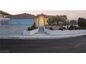 Attractive single-story house featuring a two-car garage, tile roof, and desert landscaping at dusk at 1044 Geranium Dr, Henderson, NV 89011