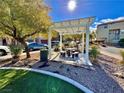 Community space featuring a pergola-covered picnic area with stone seating, surrounded by lush greenery at 10840 Holmfield St, Henderson, NV 89052