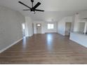 Bright, open-concept living space featuring modern ceiling fan and stylish wood-look flooring throughout the home at 121 Comstock St, Pahrump, NV 89048