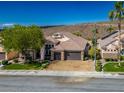 Aerial view showcasing a well-manicured lawn and a spacious three-car garage at 2012 Poetry Ave, Henderson, NV 89052