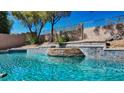 Backyard pool featuring cascading waterfall and beautiful blue tiling at 2012 Poetry Ave, Henderson, NV 89052