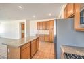 Bright kitchen features tile flooring, a center island with granite countertops, and stainless steel appliances at 2301 Bahama Point Ave, North Las Vegas, NV 89031