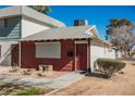 Charming townhome featuring a red door, desert landscaping, and a quaint, inviting facade at 271 Greenbriar Townhouse Way, Las Vegas, NV 89121