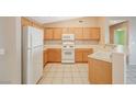 Galley kitchen with white appliances, natural wood cabinets, and light countertops at 2717 El Milagro St, Las Vegas, NV 89108