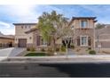 Two-story house with stone and stucco exterior, brown garage doors, and landscaped yard at 37 Carolina Cherry Dr, Las Vegas, NV 89141