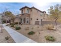 Two-story house with stone and stucco exterior, brown garage doors, and landscaped yard at 37 Carolina Cherry Dr, Las Vegas, NV 89141