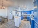 Eat-in kitchen with stainless steel appliances, white countertops, an island and blue cabinetry at 4004 Adelphi Ave, Las Vegas, NV 89120