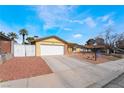 Tan single-story home features a front yard with desert landscaping and a two-car garage at 4110 Oakhill Ave, Las Vegas, NV 89121