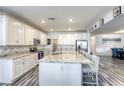 Open-concept kitchen with granite countertops, white cabinetry, stainless steel appliances, and bar seating at 4801 Westmont Dr, Pahrump, NV 89061