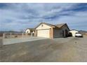 House exterior view showing a two-car garage and a driveway at 520 W Leslie St, Pahrump, NV 89060