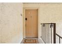 Light beige door with welcome mat. Metal railing and locks at 5493 Indian River Dr # 376, Las Vegas, NV 89103