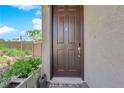 A close-up view of a solid brown front door with modern hardware and a welcoming entrance at 8719 Rio Andir Ave, Las Vegas, NV 89148