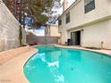 Kidney-shaped pool with surrounding patio and landscaping at 9552 Wooden Pier Way, Las Vegas, NV 89117