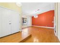 Living room with hardwood floors and an orange accent wall at 3360 Paso Andres St, Las Vegas, NV 89146