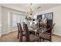 Elegant dining room featuring a glass table, a chandelier, and stylish decor at 4439 Melrose Abbey Pl, Las Vegas, NV 89141