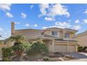 Beautiful two-story house boasts a three-car garage and lush landscaping under a partly cloudy sky at 4439 Melrose Abbey Pl, Las Vegas, NV 89141