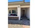 Inviting front porch features a seating area and stylish brick accents at 723 Orange Plume Walk # 0, Henderson, NV 89011