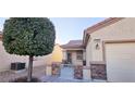 Close up of charming home entrance showcasing well-kept landscaping and wrought iron gate at 7405 Petrel St, North Las Vegas, NV 89084