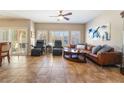 Bright living room boasts tile flooring, ceiling fan, many windows and a brown leather sofa at 830 Cozette Ct # 102, Las Vegas, NV 89144
