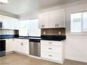 Modern kitchen with white shaker cabinets, dark countertops, and tile backsplash at 1470 Sutton Dr, Pahrump, NV 89048