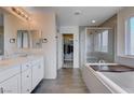Spa-like bathroom featuring double vanities, a soaking tub, a walk-in shower, and a spacious closet at 422 Barcarolle Ln, Henderson, NV 89011