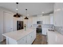 Bright, modern kitchen with stainless steel appliances, quartz countertops, large island, and light wood flooring at 422 Barcarolle Ln, Henderson, NV 89011