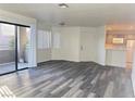 Living room with gray vinyl flooring, access to a balcony, and an open floor plan at 5002 S Rainbow Blvd # 106, Las Vegas, NV 89118