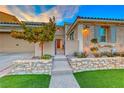 Inviting front entry with stonework and landscaping at 61 Contrada Fiore Dr, Henderson, NV 89011