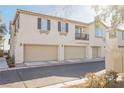 Rear view of townhome showing attached garages and a balcony at 7332 Marble Lake St # 103, Las Vegas, NV 89149
