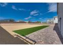 Landscaped backyard with artificial turf and paver patio at 8541 S Pioneer Way, Las Vegas, NV 89113