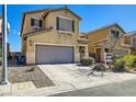 Two-story home with tan stucco, two-car garage, desert landscaping, and clear blue skies at 8956 Rutherford Grove St, Las Vegas, NV 89148