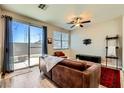 A well-lit living room featuring a sliding door to the patio, ceiling fan, and wood-look floors at 8956 Rutherford Grove St, Las Vegas, NV 89148