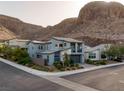 Street view showcasing a contemporary two-story home with desert landscaping near mountains at 1945 Canyon Highlands Dr, Henderson, NV 89052