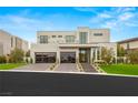 Contemporary two-story home with modern curb appeal, featuring a manicured lawn, and glass paneled garage doors at 21 Grey Owl Ct, Las Vegas, NV 89135