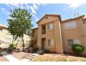 Exterior of a tan apartment building featuring outdoor staircases and a neatly landscaped yard at 2110 Los Feliz St # 2052, Las Vegas, NV 89156