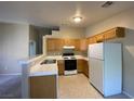 Kitchen with light wood cabinets and white appliances at 2110 Los Feliz St # 2052, Las Vegas, NV 89156