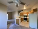 Kitchen with light wood cabinets, white appliances, and a breakfast bar at 2110 Los Feliz St # 2052, Las Vegas, NV 89156