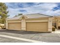 Two-car garage with tan doors and stucco exterior at 448 Wonderstone Dr, Las Vegas, NV 89107