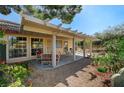 Relaxing covered patio area with comfortable seating and mature landscaping at 5105 Kingsbridge Dr, Las Vegas, NV 89130