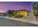 Well-manicured, single-story home with a 2-car garage and stone accents, featuring a lush desert landscape at 6425 Orto Botanico Ct, Las Vegas, NV 89131