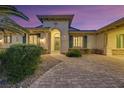 Inviting front entrance with a brick walkway, complemented by beautiful landscaping and a decorative green door at 6425 Orto Botanico Ct, Las Vegas, NV 89131