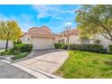 Lovely home exterior with a tile roof, a paved driveway leading to a two-car garage, and mature landscaping at 6914 Emerald Springs Ln, Las Vegas, NV 89113