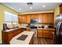 Kitchen with wood cabinets, stainless steel appliances, and an island at 8063 Sundance Valley Dr, Las Vegas, NV 89178