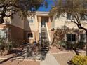 Exterior of a two-story condo featuring private entrance, desert landscaping, and neutral color scheme at 10524 Pine Gardens Ct # 203, Las Vegas, NV 89144