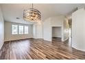 Open-concept living space featuring wood-look tile and contemporary lighting fixture at 10649 Bella Ordaz Way, Las Vegas, NV 89141