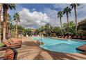 Inviting pool area with numerous lounge chairs and palm trees at 1700 Hills Of Red Dr # 202, Las Vegas, NV 89128