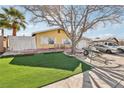Inviting home exterior featuring a well-maintained front yard with a green lawn, mature trees and cozy facade at 6409 Youngmont Ave, Las Vegas, NV 89103