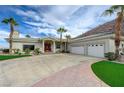 Elegant home featuring a three-car garage, tile roof, palm trees, and well-manicured lawn for curb appeal at 215 Granite Ct, Boulder City, NV 89005