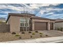 Tan three-car garage home with drought-tolerant landscaping at 3395 Sleeping Hills Ave, Henderson, NV 89044