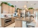 Modern kitchen with light wood cabinets, granite island, and stainless steel appliances at 3395 Sleeping Hills Ave, Henderson, NV 89044